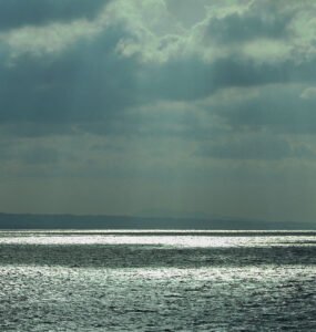 View of the Aegean Sea with dark clouds and sunbeams.