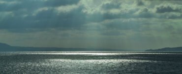 View of the Aegean Sea with dark clouds and sunbeams.