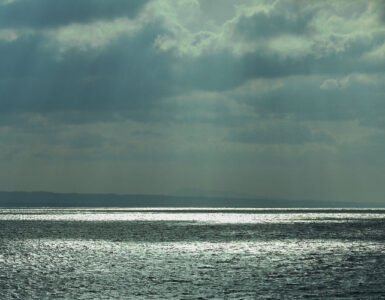 View of the Aegean Sea with dark clouds and sunbeams.