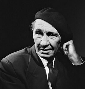 Black and white portrait of Cevat Sakir Kabaagacli, the Fisherman of Halicarnassus, wearing a beret and suit, symbolizing his intellectual legacy in Bodrum.