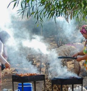 Four women in local dresses are cooking on a picnic at Bodrum coast