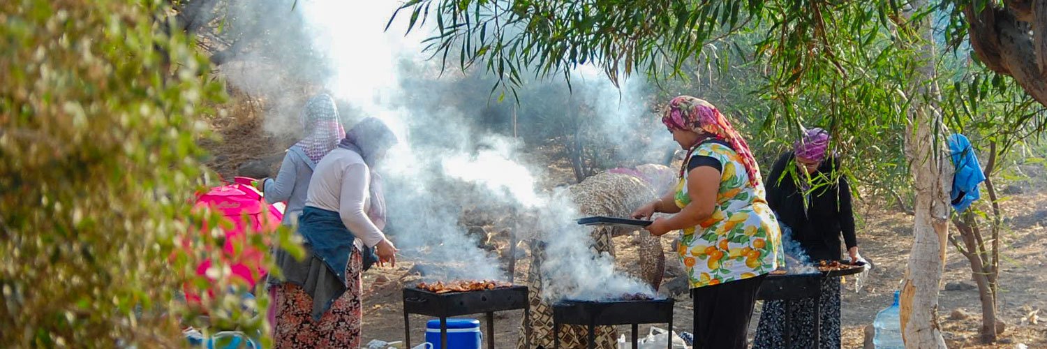 Four women in local dresses are cooking on a picnic at Bodrum coast