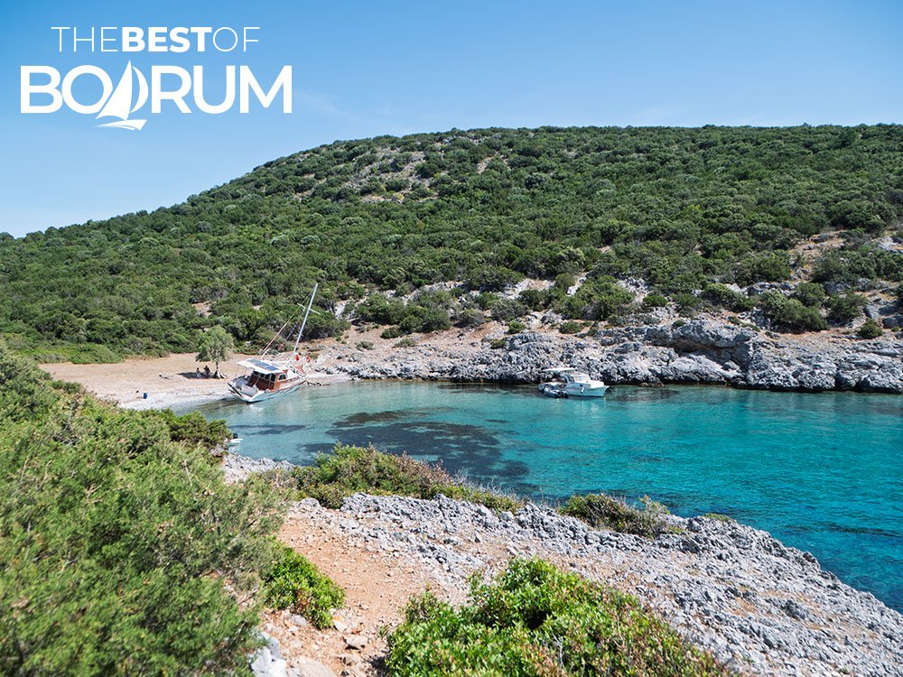 Aquarium Bay with turquoise water and boats anchored at one of the hidden beaches in Bodrum.