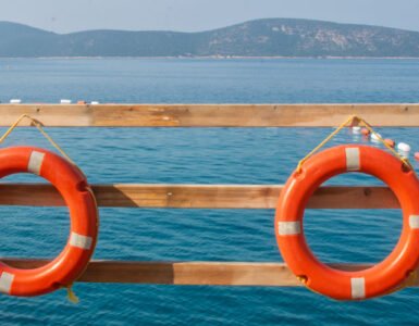 Featured photo of Yelken Beach with umbrellas and shoreline, representing beaches in Bodrum.