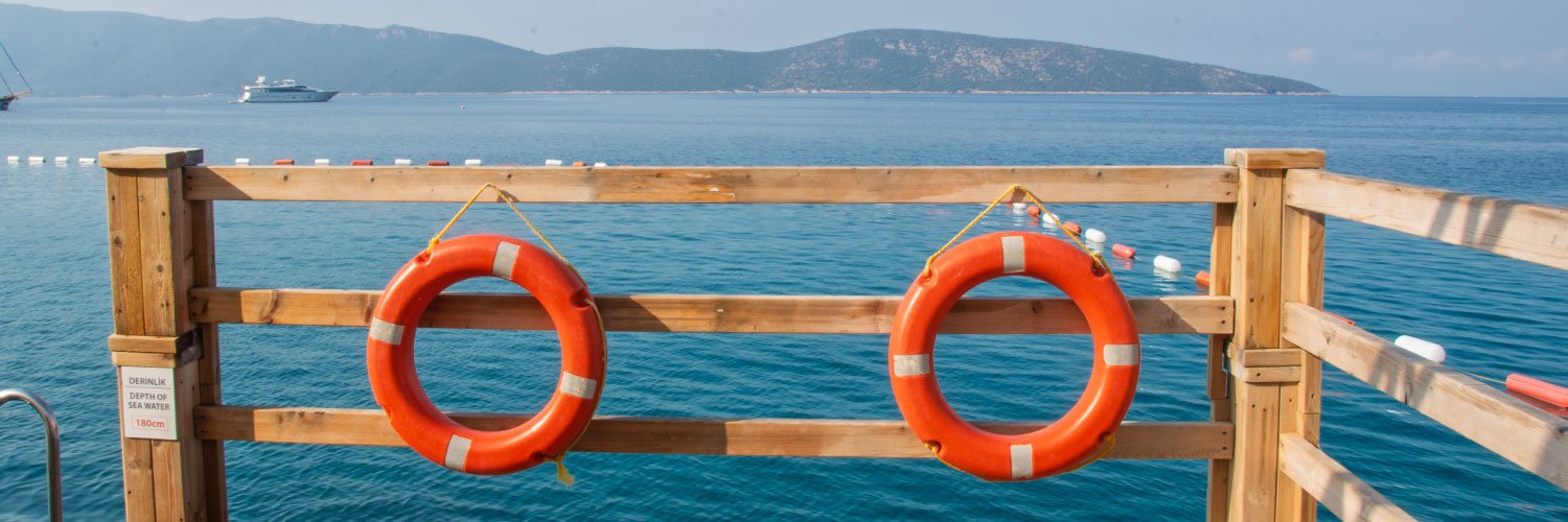 Featured photo of Yelken Beach with umbrellas and shoreline, representing beaches in Bodrum.
