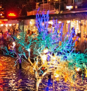 Colourful reflections from Bodrum’s waterfront restaurants glowing over the water at night.