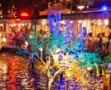 Colourful reflections from Bodrum’s waterfront restaurants glowing over the water at night.