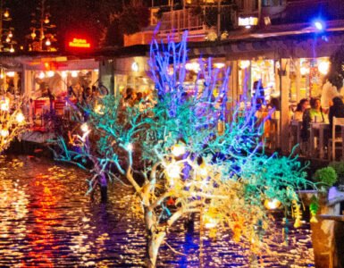 Colourful reflections from Bodrum’s waterfront restaurants glowing over the water at night.