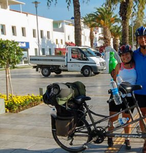 Two travellers on a tandem bicycle posing for a photo at Bodrum Harbour on their Turkey journey.