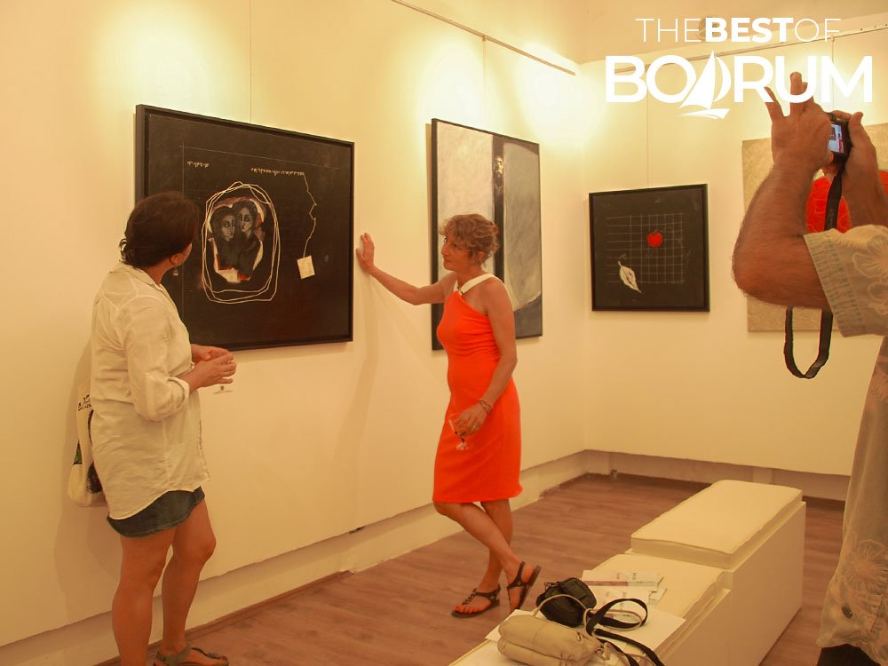 Visitors viewing paintings at a local art gallery in Bodrum during an exhibition, showing the artistic side of Bodrum attractions.