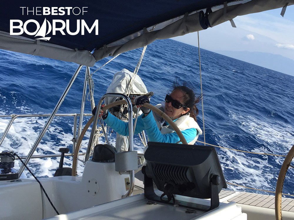 Pırıl Adanalı steering a sailing boat during one of her adventures, representing experienced sailing women from Bodrum.