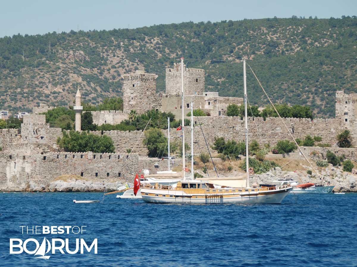 Bodrum Castle seen from the sea with a wooden gulet in the foreground